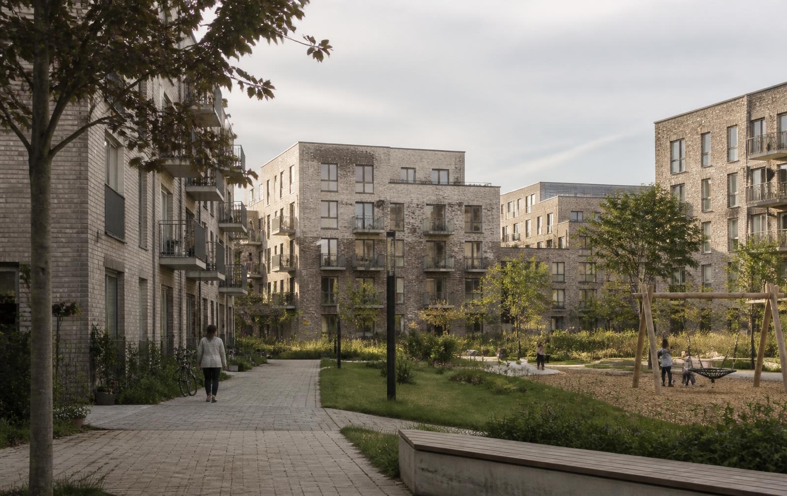 Woonbuurt met lage appartementengebouwen rond een groene collectieve binnenruimte